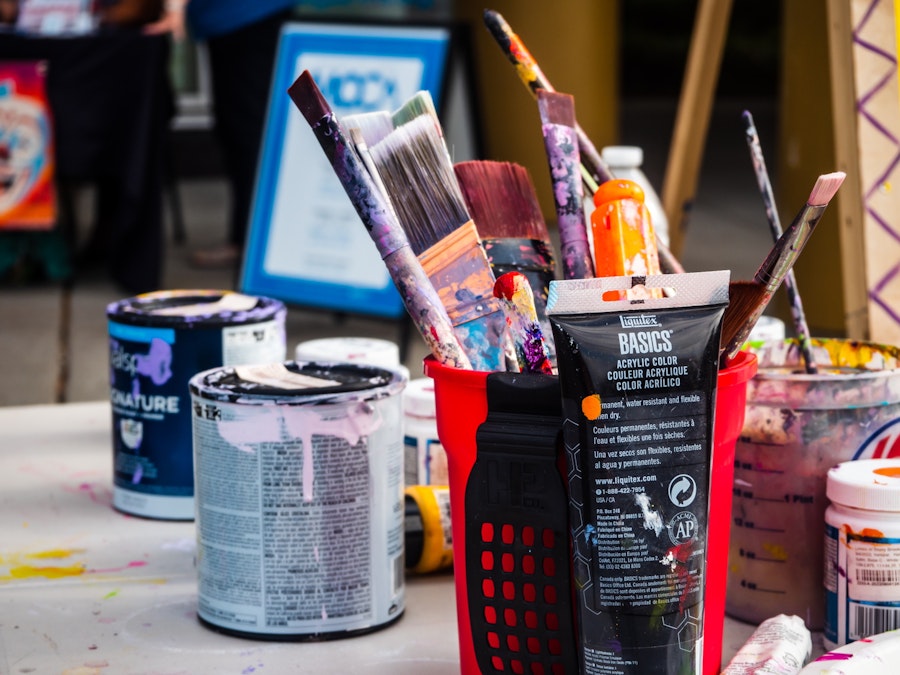 Photo: Paint brushes and cans of paint on a table