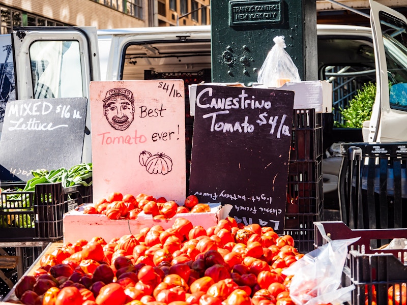 Photo: A bunch of tomatoes for sale with a black and white chalkboard sign