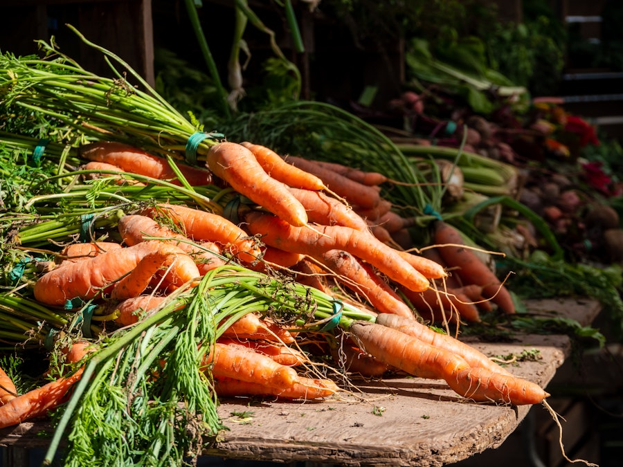 Photo: A bunch of carrots on a table at a farmers market 