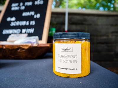 Glass Jar of Lip Scrub on Table - A jar of turmeric scrub on a table at a market