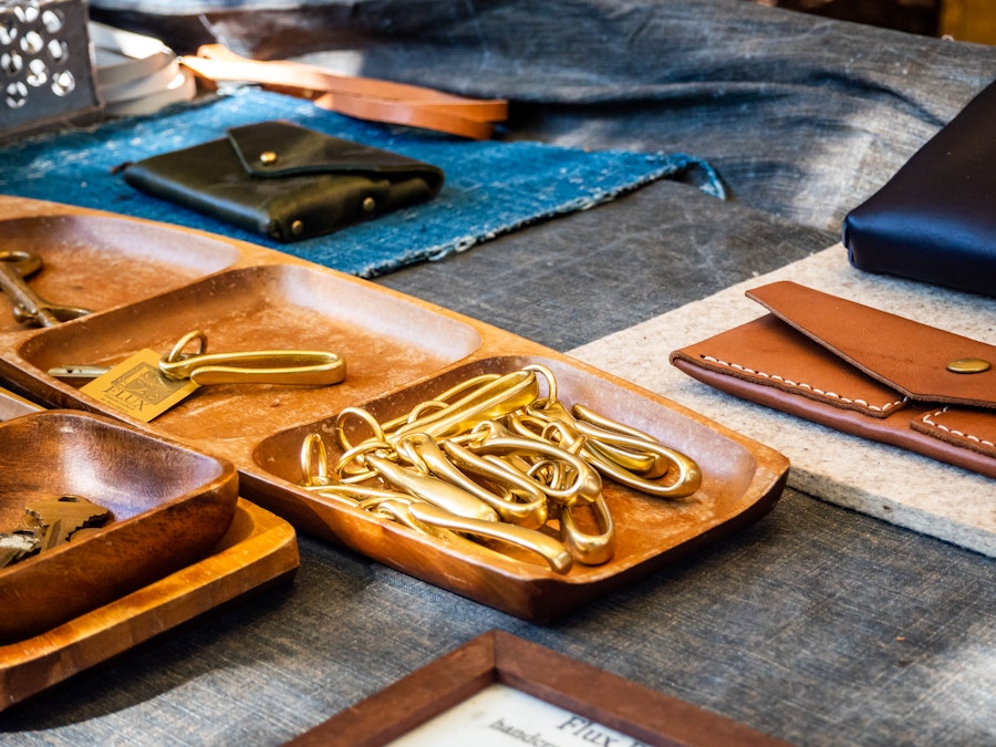 Photo: Trays of gold objects and leather wallets on a table at an artist market