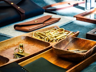 Handmade Leather Goods for Sale - Trays of metal objects and wallets at an artist market