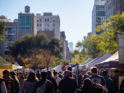 People at Farmers Market - A crowd of people walking down a farmers market in a park