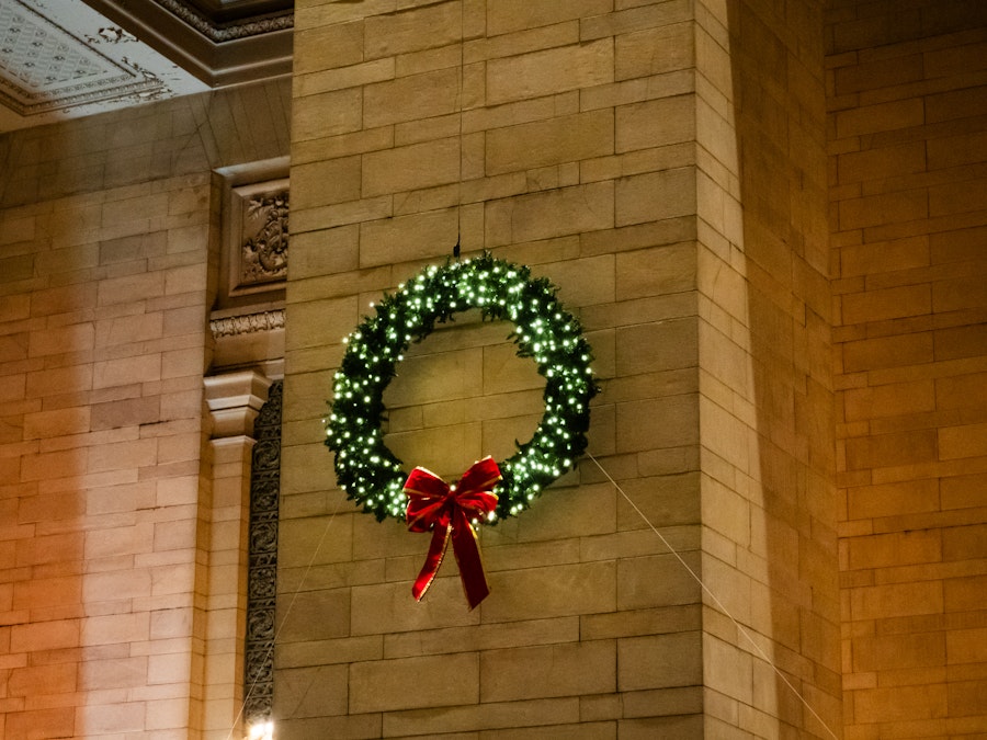 Photo: A wreath with lights and a bow on a wall