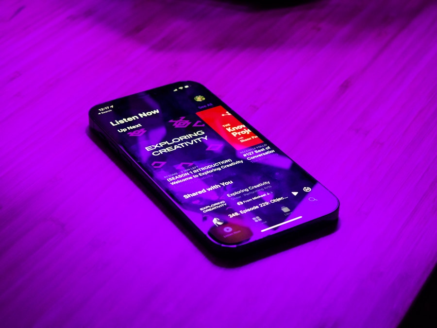 Photo: A smartphone on a table under purple lighting