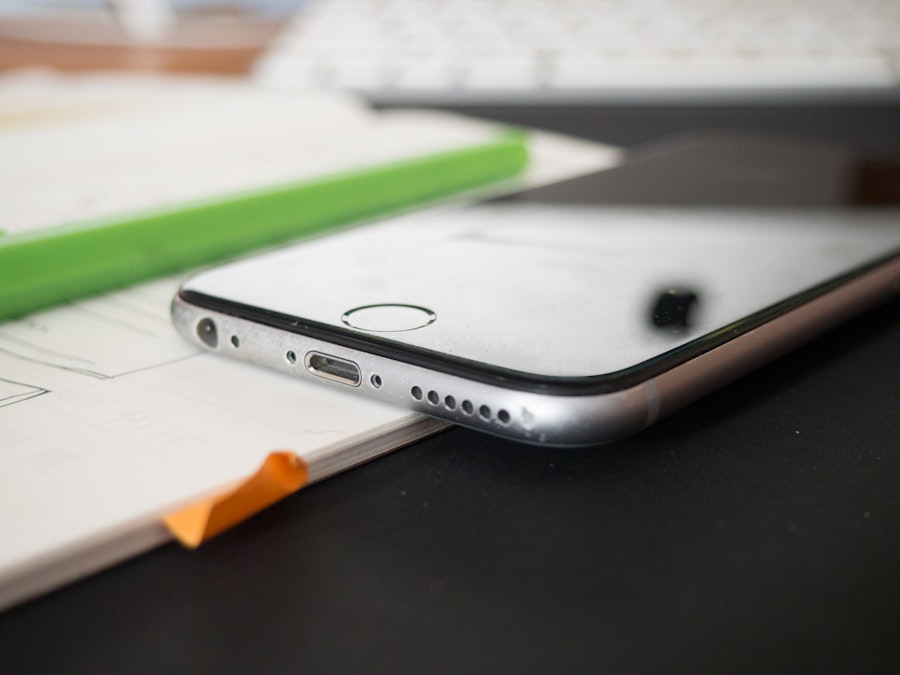 Photo: Open Notebook and Phone on Desk