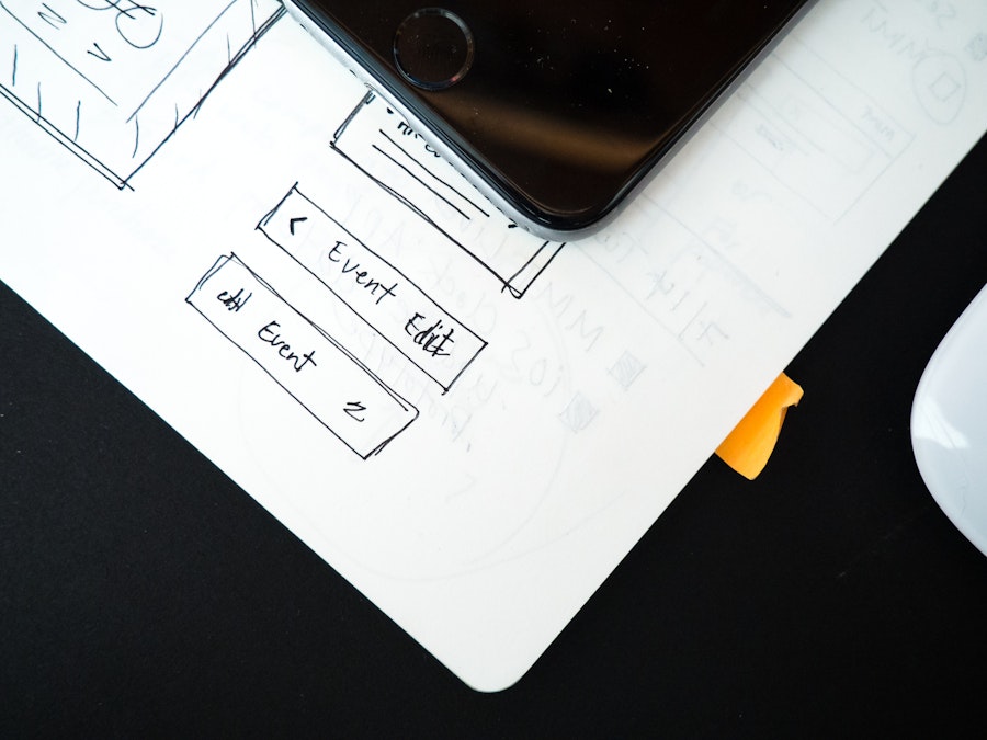 Photo: Notebook, Mouse, and Phone on Black Desk