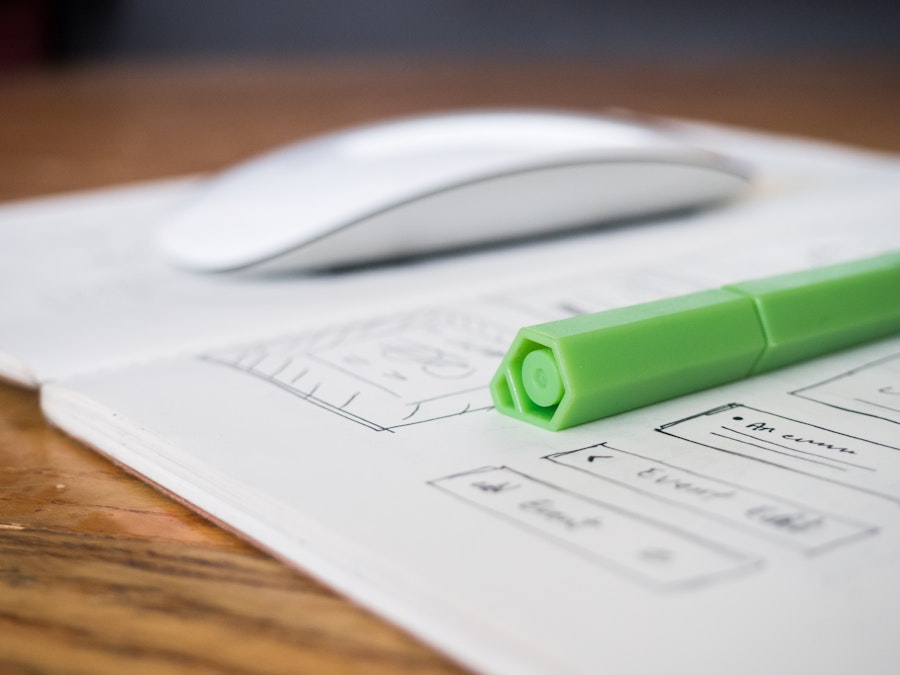 Photo: Green Pen and Sketchbook on Desk